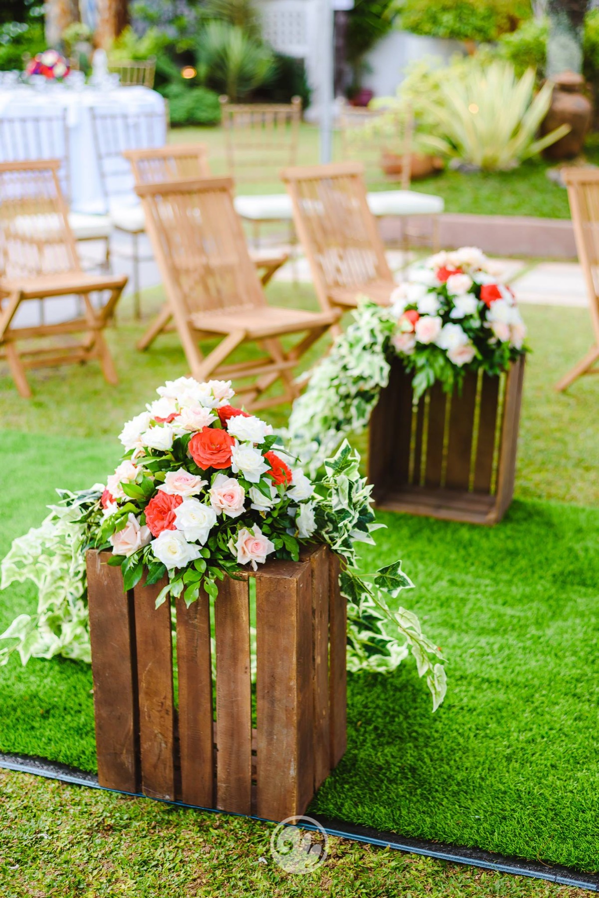 Red and white floral arrangement along the ceremony aisle