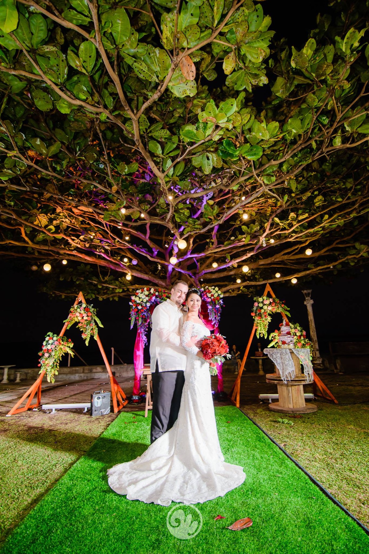 Couple posing beneath the Talisay tree ceremony arch