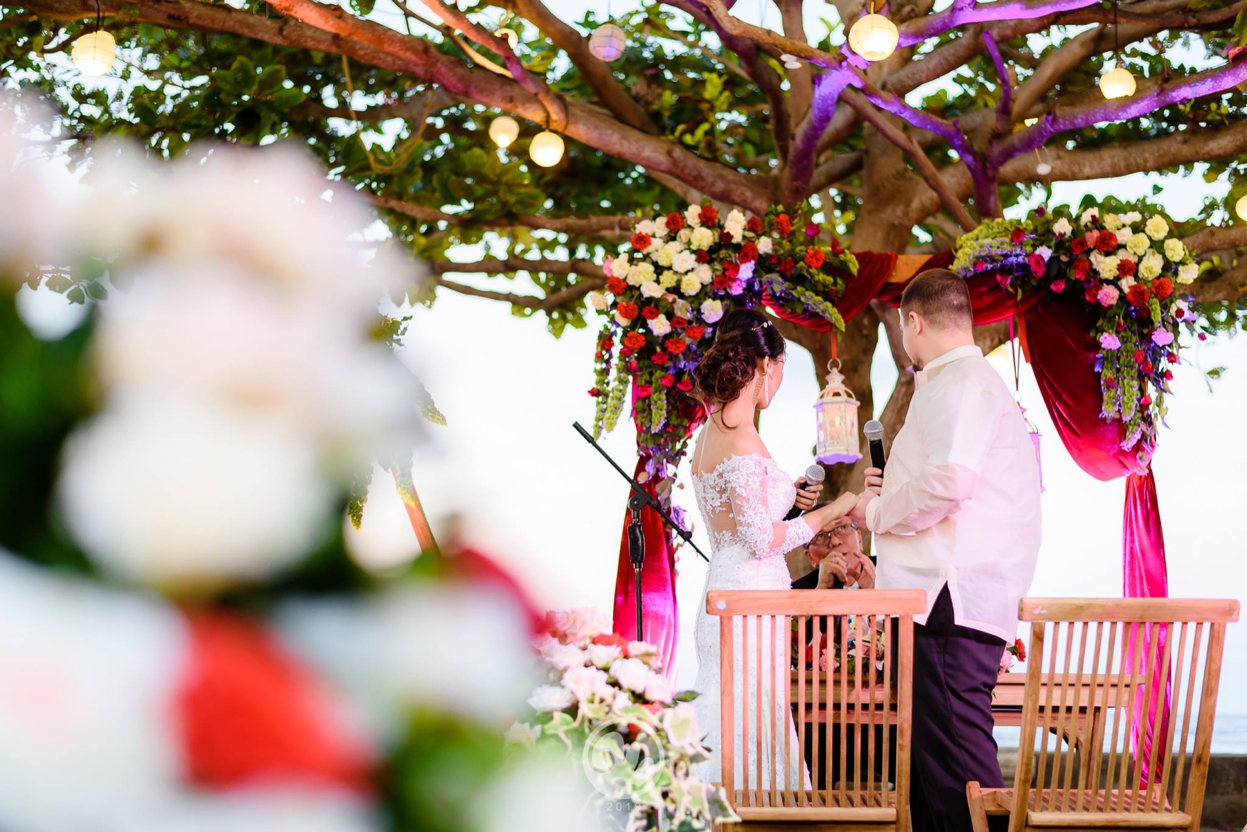 Wedding vows framed by flowers and the Talisay tree