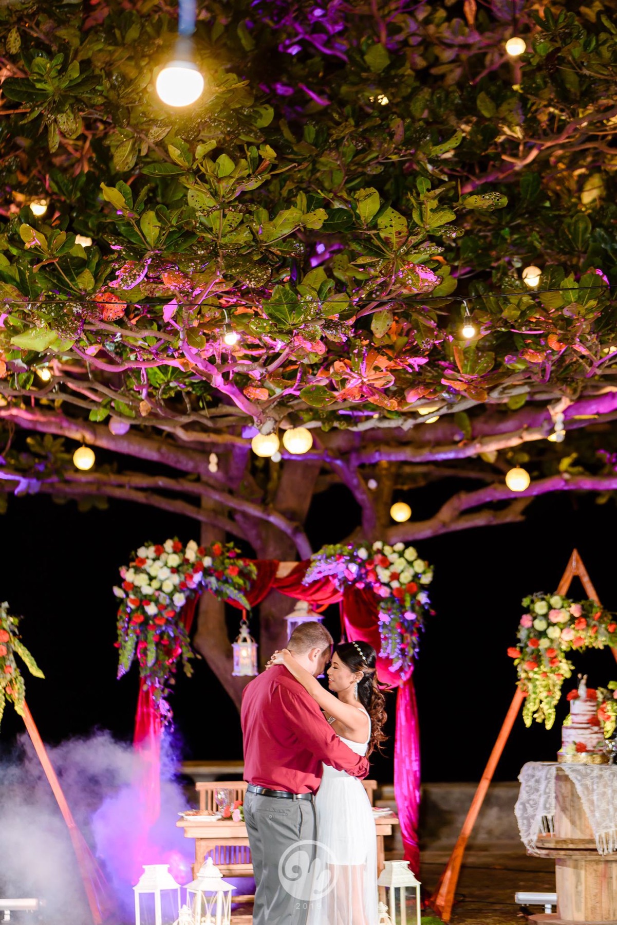 Newlyweds sharing a quiet moment beneath the ceremony flowers