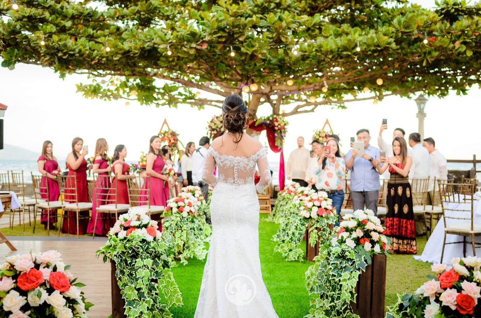 Bride walking toward a beachfront garden ceremony